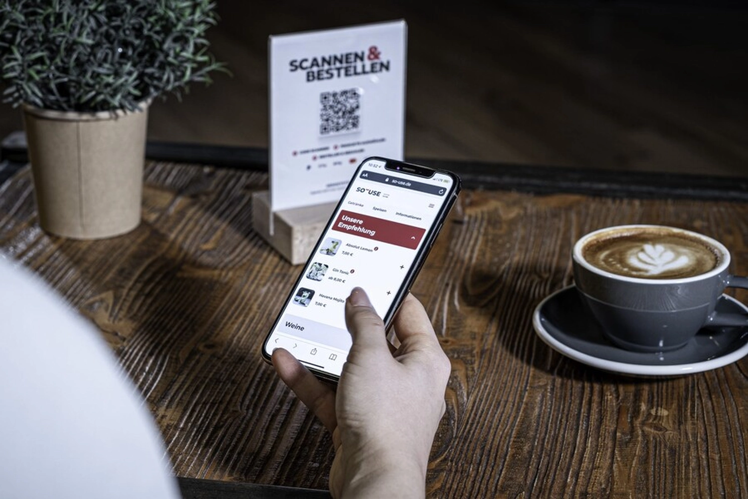Gast scannt den QR-Code am Tisch für die Bestellung im Café