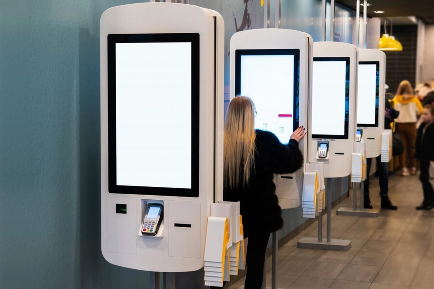 Kasse Südwest - This image depicts a professional call center or customer support environment. It features two women wearing communication headsets while working at computers, likely providing telemarketing, technical support, or insurance advisory services. 